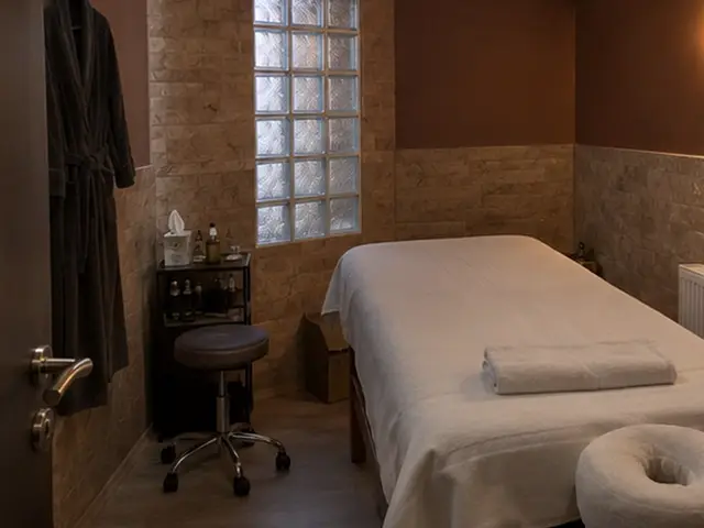 Taş duvarlı odada yüz yastıklı masaj masası — Bebek, Masaj Salonun